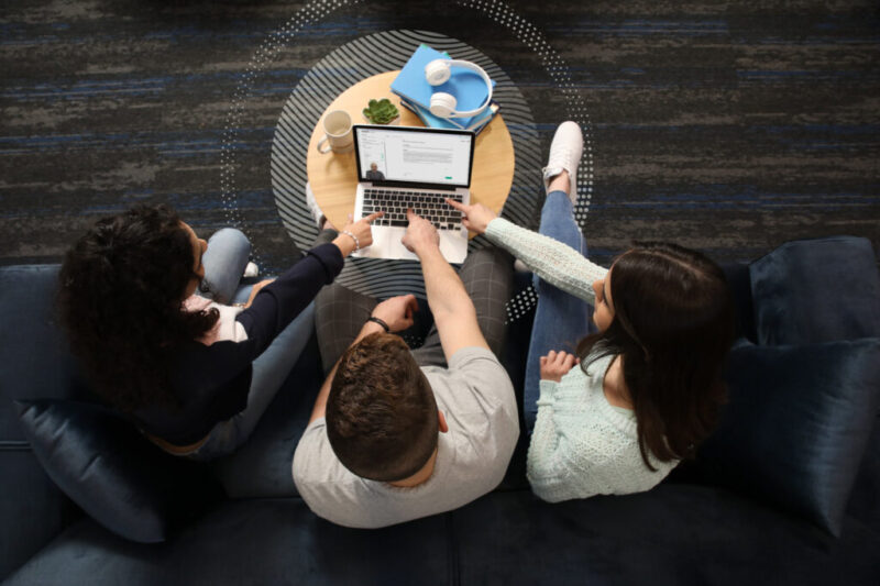 three students looking at the AI bot on laptop