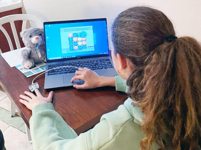 A young female kid using laptop for Biofeedback