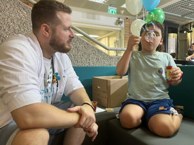 A boy blowing bubbles next to a student